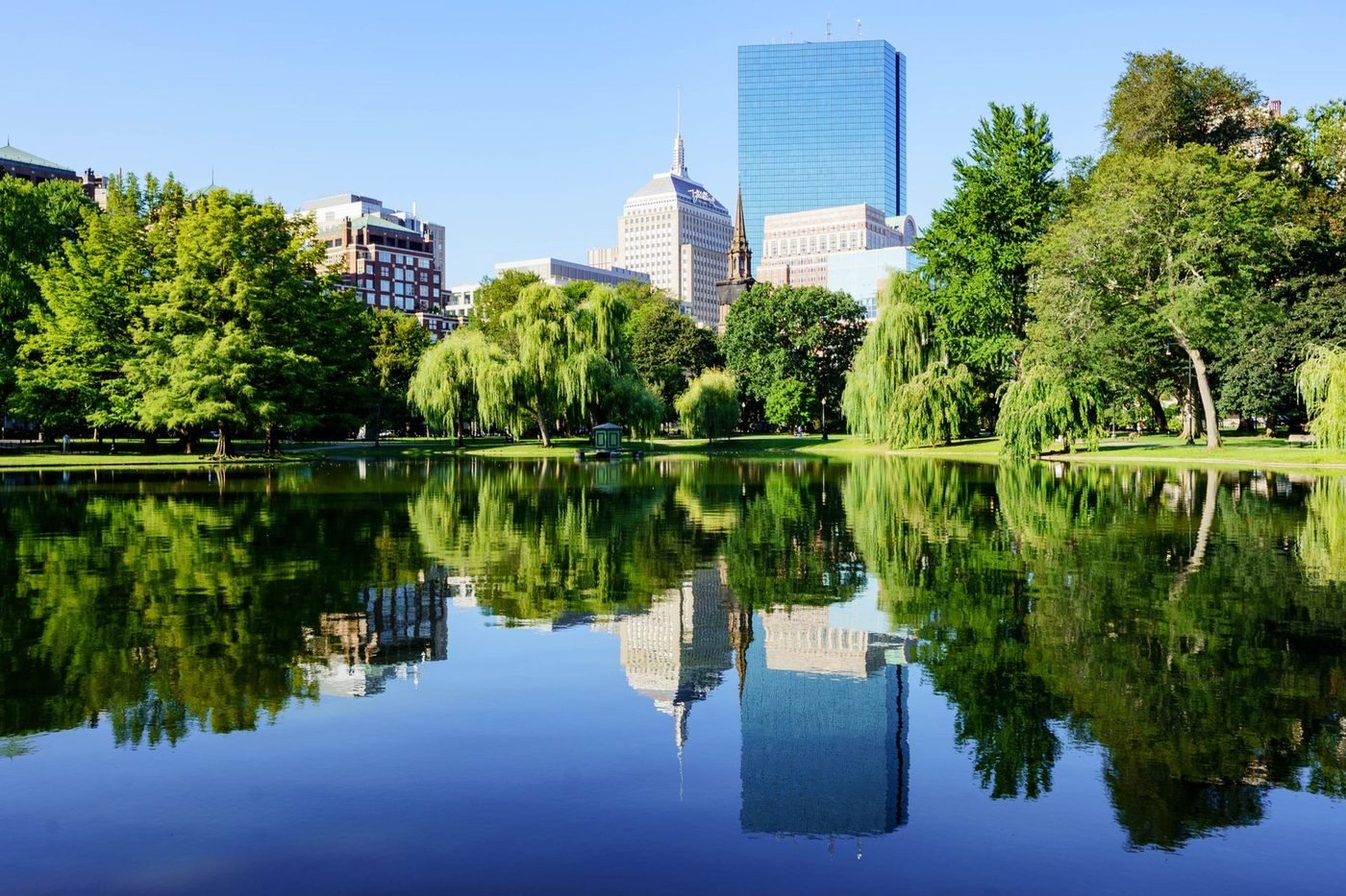 Boston skyline reflected in the Public Garden pond on a sunny day